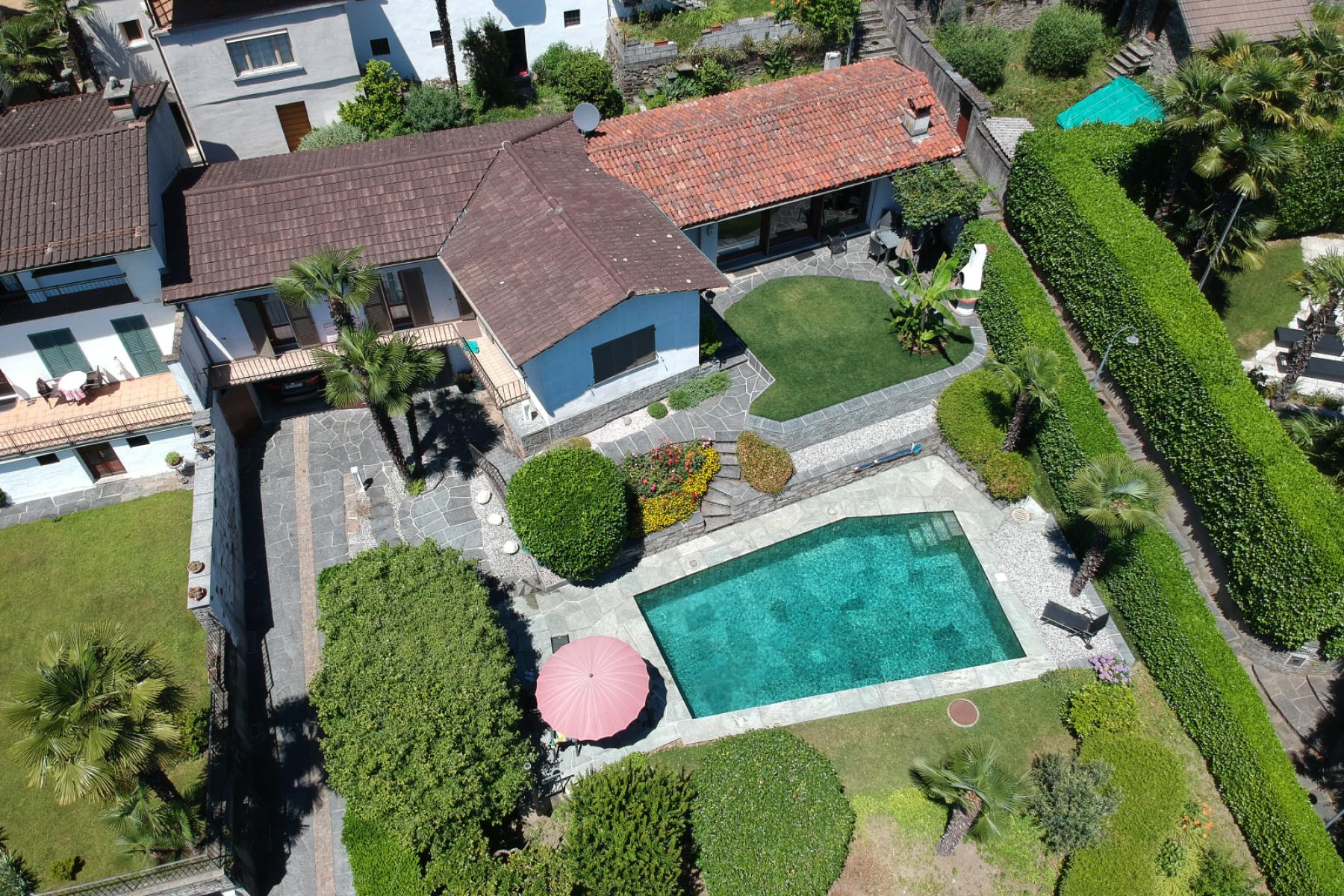 Die Drohnen-Luftaufnahme des Ferienhauses Casa Ramerino in Brissago zeigt ein beeindruckendes Bild. Das Schwimmbad fügt sich perfekt in die Umgebung ein