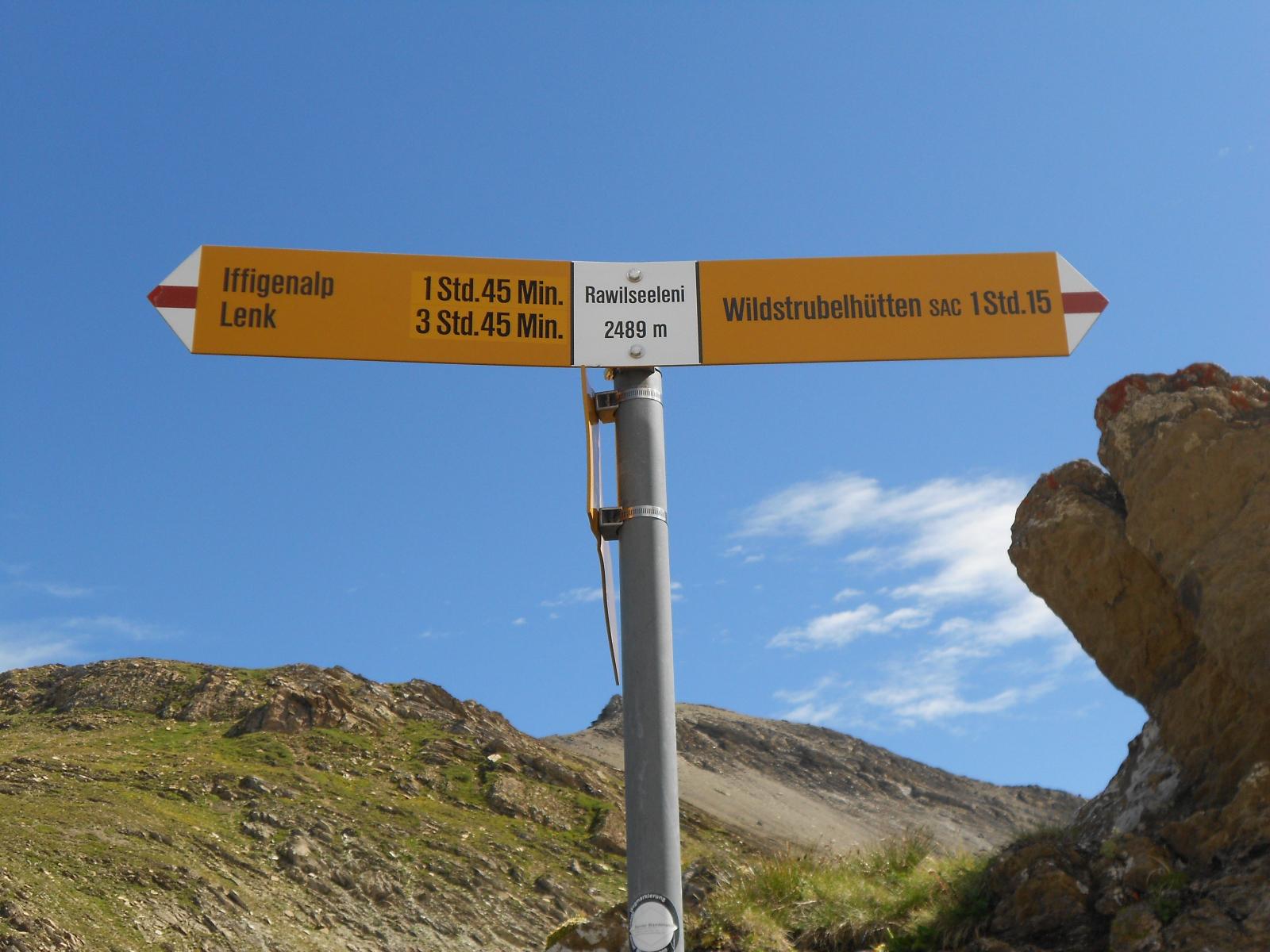 Das Rawilseeleni ist ein Gebirgssee, der von den majestätischen Gipfeln der Wildhorn- und Wildstrubelberge umgeben ist. Das Bild zeigt einen Bergwanderweiser