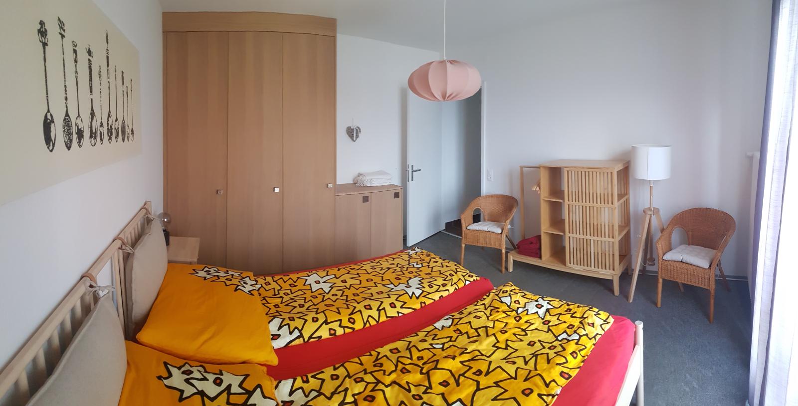 Insgesamt strahlt das Schlafzimmer mit seinem Doppelbett und der eleganten Ästhetik ein ruhiges und ansprechendes Ambiente aus. Das Bild zeigt ein Teil des Schlafzimmer mit bezogenen Betten