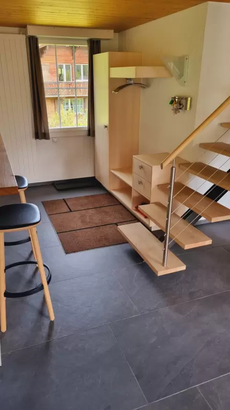 Der grosszügige Eingang im Chalet Catarina im 1. Stock verfügt über eine geräumige Garderobe. Das Bild zeigt vom Eingang her die Garderobe sowie der Esstisch.