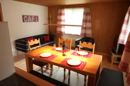 Der Wohnraum im Chalet Catarina im Parterre an der Aegertenstrasse 33 ist äusserst charmant, welcher zu geselligen Mahlzeiten und gemütlichem Beisammensein einlädt. Das Bild zeigt den Esstisch, richtung Wohnraum.