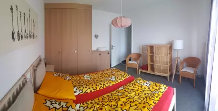 Insgesamt strahlt das Schlafzimmer mit seinem Doppelbett und der eleganten Ästhetik ein ruhiges und ansprechendes Ambiente aus. Das Bild zeigt ein Teil des Schlafzimmer mit bezogenen Betten
