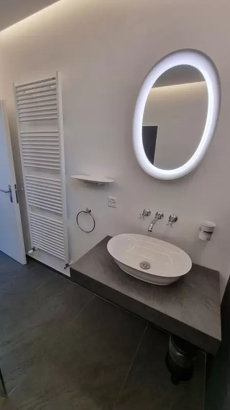 Eine grosse offene Dusche mit integriertem WC, ausgestattet mit rustikalen Armaturen. Das Bild zeigt einen Auschnitt von der Dusche mit WC