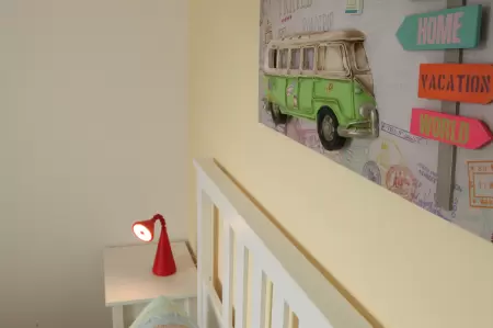 Insgesamt strahlt das liebevoll gestaltete kleine Kinderzimmer eine einladende und kinderfreundliche Atmosphäre aus. Das Bild zeigt ein Wandbild