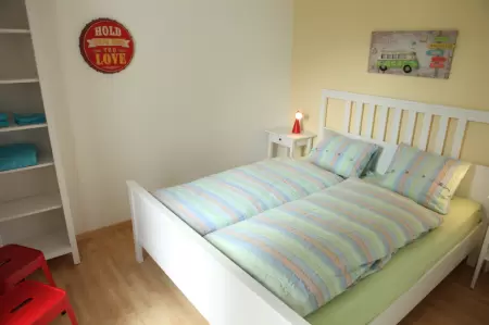 Die liebevolle Gestaltung des Zimmers schafft eine gemütliche Atmosphäre, in der sich die kleinen Gäste wohlfühlen können. Das Bild zeigt das Zimmer mit dem Doppelbett