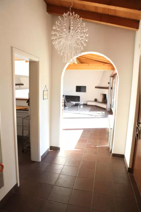 Das Casa Ramerino, mit seinem grosszügigen Eingangsbereich und der geräumigen Garderobe, bietet ausreichend Platz für alle Gäste. Das Bild zeigt ein Teil des Ganges inkl. sicht in den Wohnraum.