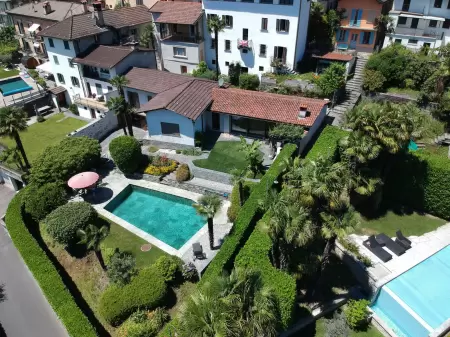 Die Drohnen-Luftaufnahme des Ferienhauses Casa Ramerino in Brissago zeigt ein beeindruckendes Bild. Das Schwimmbad fügt sich perfekt in die Umgebung ein.