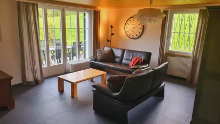 Das Wohnzimmer im Chalet Catarina im 1. Stock ist das Herzstück der Ferienwohnung. Das Bild zeigt einen Ausschnit Richtung Küche nund Esstisch.