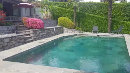 Das Casa Ramerino in Brissago beeindruckt mit seinem einfachen, aber dennoch grünen Garten. Der Pool, Scheimmbad ist optimal eingebetet in den Garten