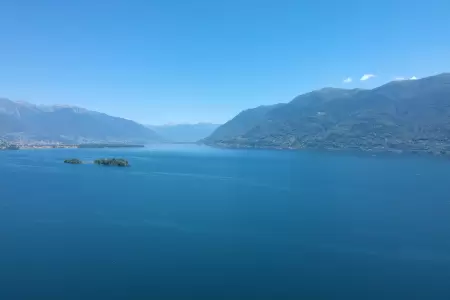 Der Ausblick auf den Lago Maggiore vom Ferienhaus Casa Ramerino aus ist absolut atemberaubend. Die Drohnen-Aufnahme zeigt den Blick nach Ascona, wobei die malerischen Brissago-Inseln im Mittelpunkt steht.